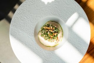 Onze chef begint met zwezerik als basis, voegt de frisse smaak van zuurkool toe, de diepe toon van paling en een subtiele kick van sambai.